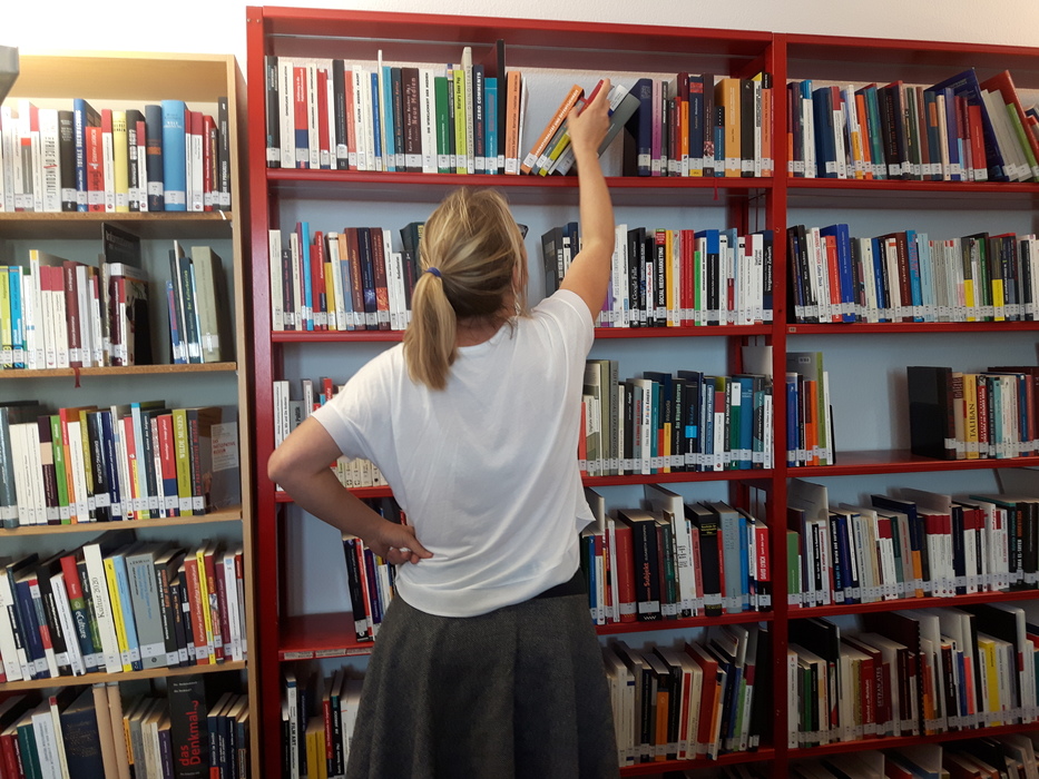 Frau vor einem großen Bücherregal